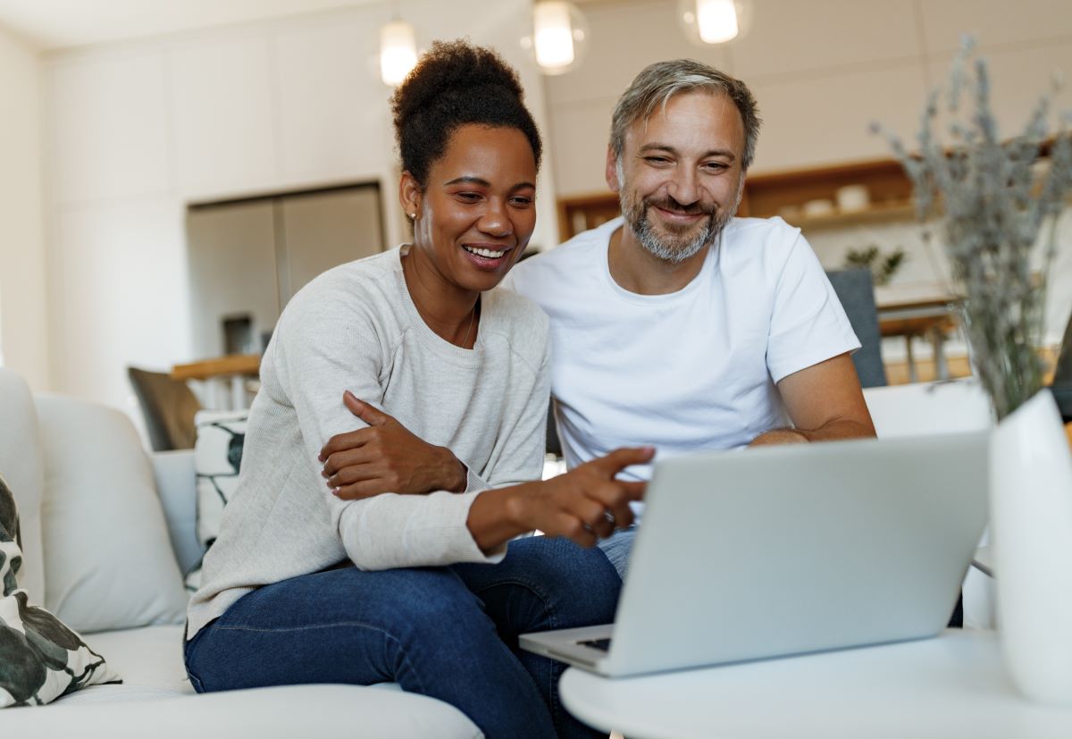 Diverse couple looking at a laptop
